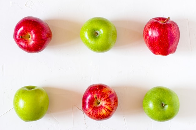 Red and Green Apples on white table.