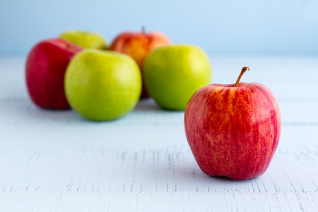 Red and Green Apples on wooden blue table.