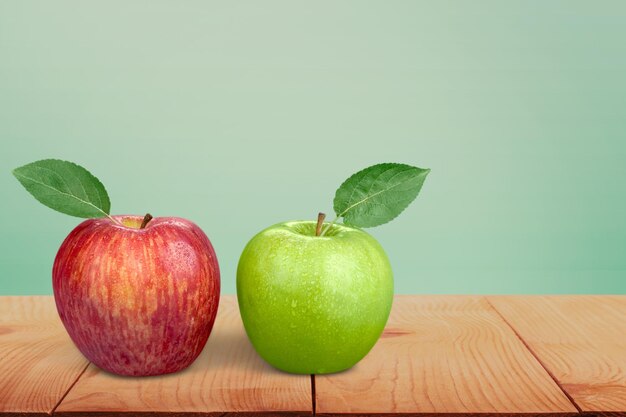 Red and green apples on wooden table