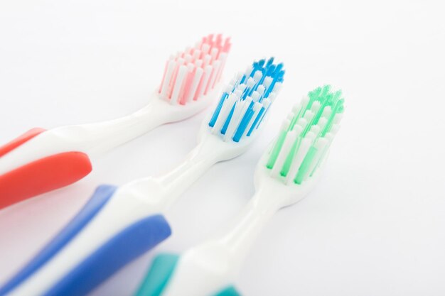 Red green and blue toothbrush over white