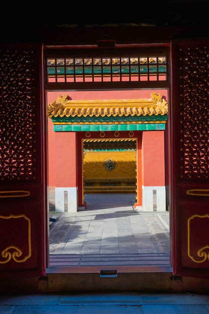 A red and green gate with a yellow roof and a green roof.