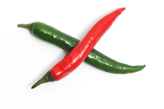 Red and green hot chili pepper top view cross photo concept isolated on white background
