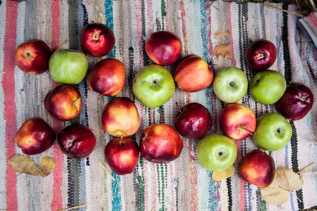 Red and green ripe apples lie on an authentic carpet