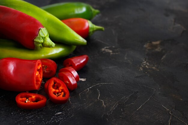 Red and green sweet peppers on dark  background