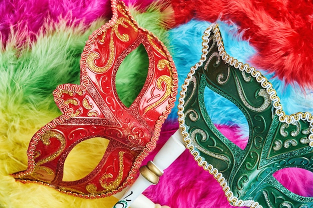 Maschera veneziana rossa e verde, maschera di carnevale su sfondo colorato