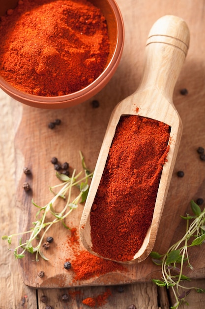 Spezia rossa della paprika macinata in cucchiaio e ciotola di legno