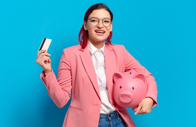 Red hair cool woman with piggy bank