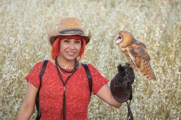 Red hair woman with a white owl on her arm 