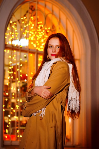 Foto ragazza dai capelli rossi in una sera d'inverno sulla strada