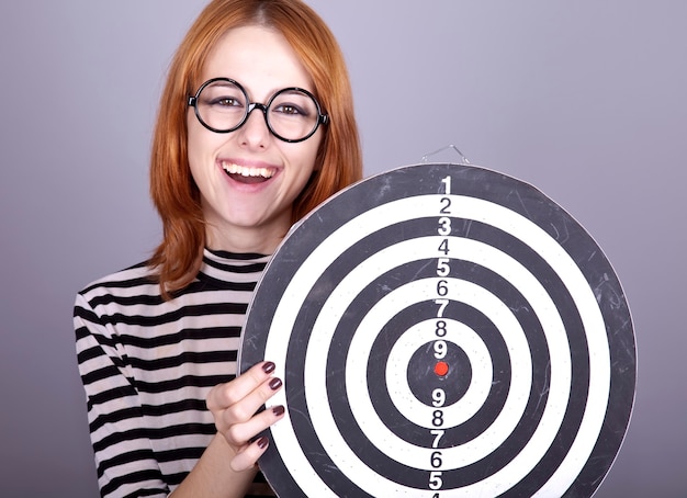 Red-haired girl with dartboard. 