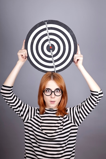 Photo red-haired girl with dartboard.