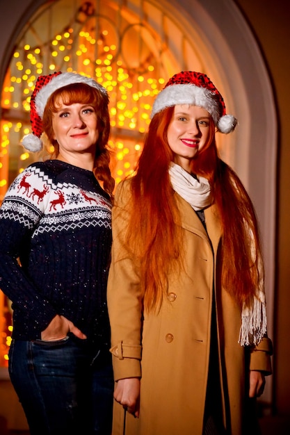 red-haired girl with her mother in the winter evening on the street