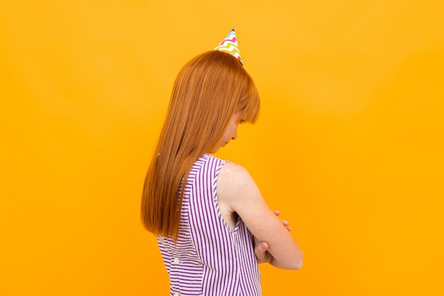 Red-haired girl with a holiday cap turned back