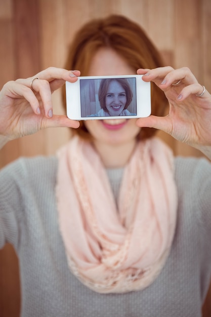 Red haired hipster taking selfie