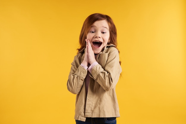 Red haired little girl admires something