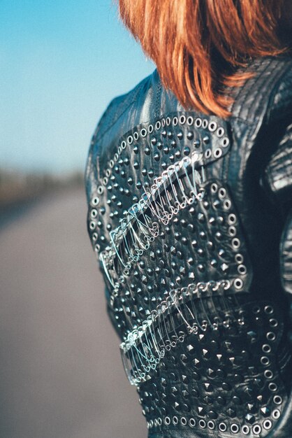 Red-haired woman in a black leather jacket on the road