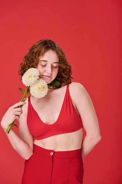 Red haired young girl with flowers