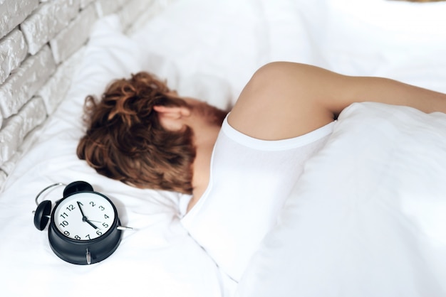 Red haired young man sleeps in bedroom