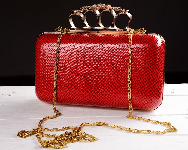 Red hand bag clutch with pen brass knuckle on black