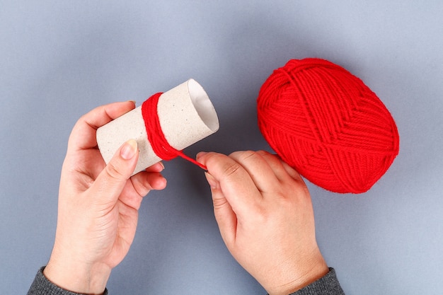 Red handmade diy monster pom pom from yarn, chenille stems in shape heart.