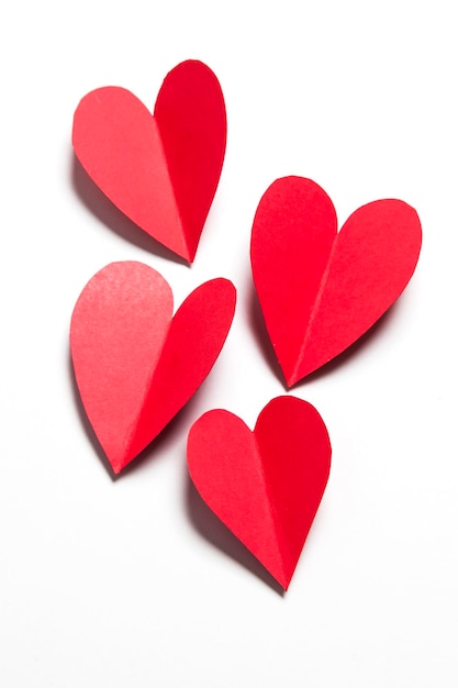 Red handmade paper hearts on a white background