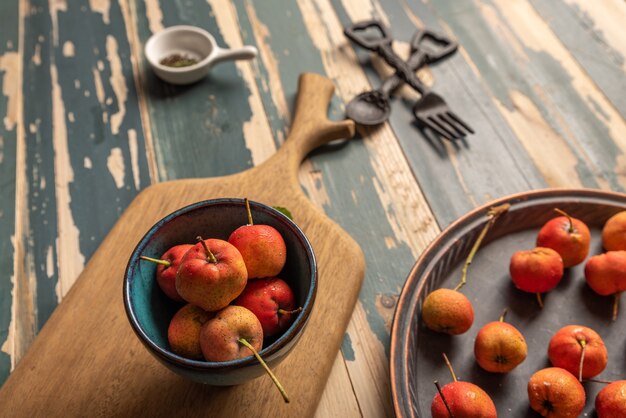 The red Hawthorn in the bowl is placed on the wooden table