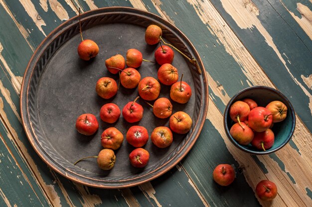 Photo red hawthorn on a plate or scattered on a wooden table