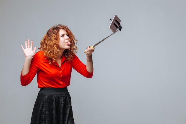 모노 포드에 전화에 selfie를 복용 빨간 머리 소녀