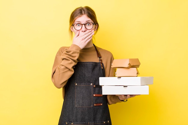 Red head pretty woman covering mouth with hands with a shocked\
fast food take away tender