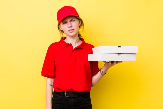 Red head pretty woman feeling puzzled and confused delivery pizza concept