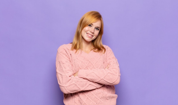 Red head pretty woman laughing happily with arms crossed, with a relaxed, positive and satisfied pose