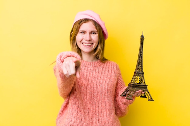 Donna graziosa della testa rossa che indica alla macchina fotografica che ti sceglie il concetto francese