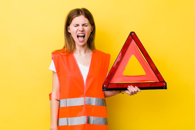 Red head pretty woman shouting aggressively looking very angry car triangre danger