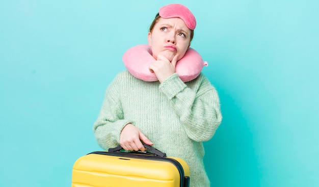 Red head pretty woman thinking feeling doubtful and confused flight passenger concept