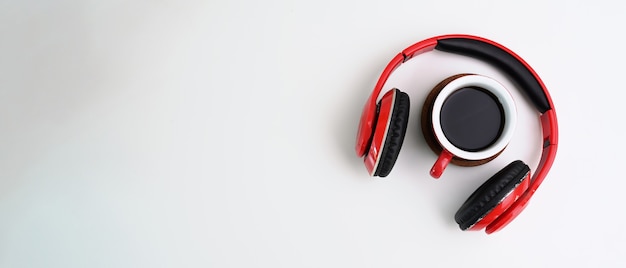 Red headphone and coffee cup in white background