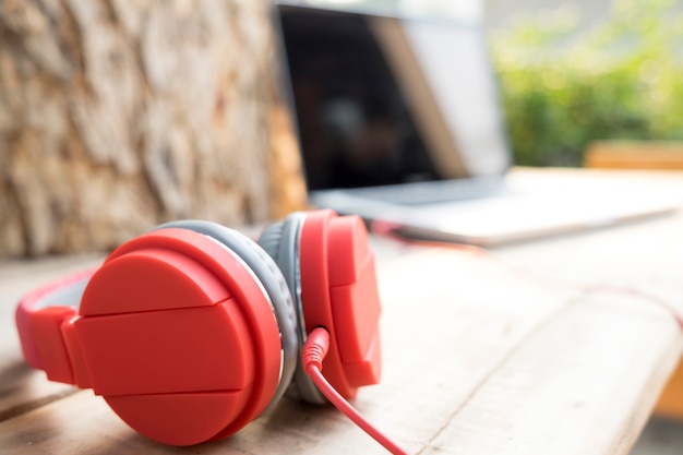 Red headphone on wooden table.