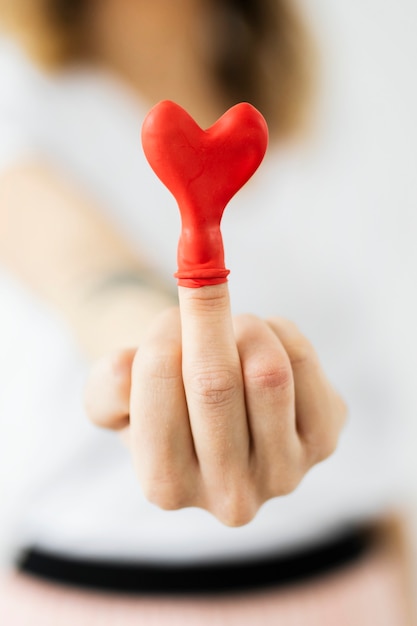 Palloncino cuore rosso su un dito medio