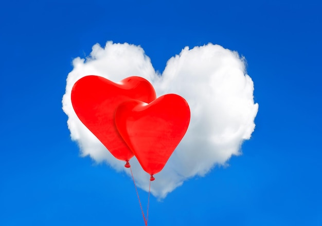Фото Красные сердечные шары и белое облако в идеальном голубом небе. концепция дня святого валентина