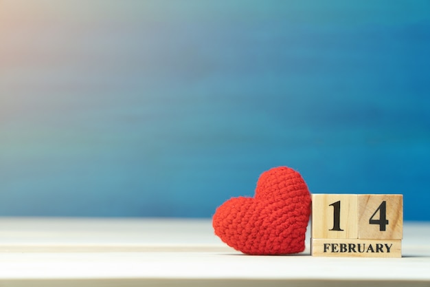 Photo red heart beside wooden block calendar