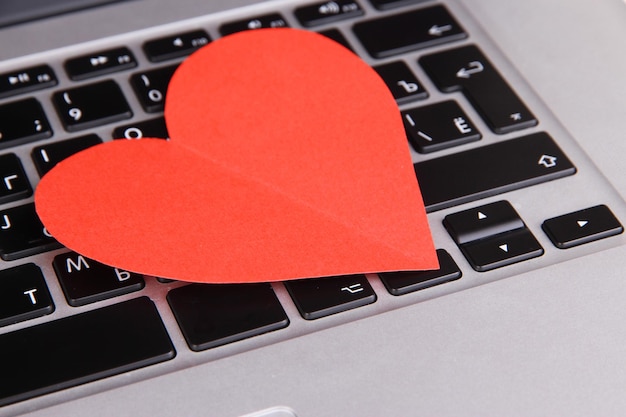 Photo red heart on computer keyboard close up