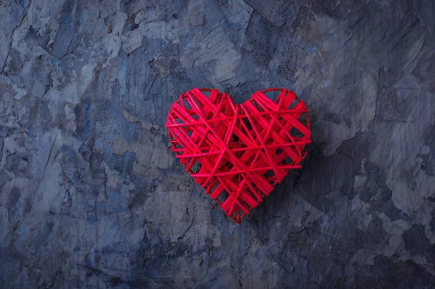 Red heart on concrete background, top view