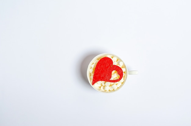 Foto cuore rosso in una tazza con marshmallow