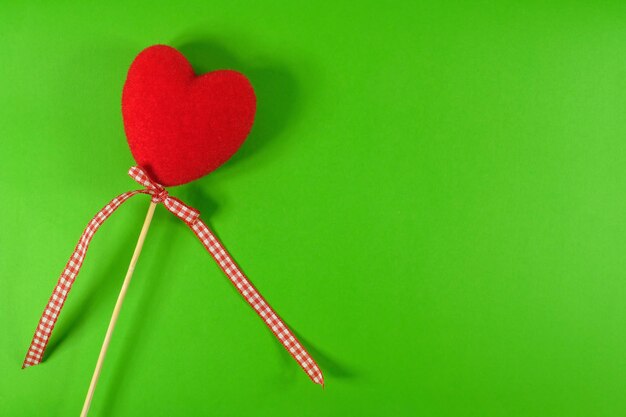 Red heart on a green paper background Close up top view Valentines day card with red hearts