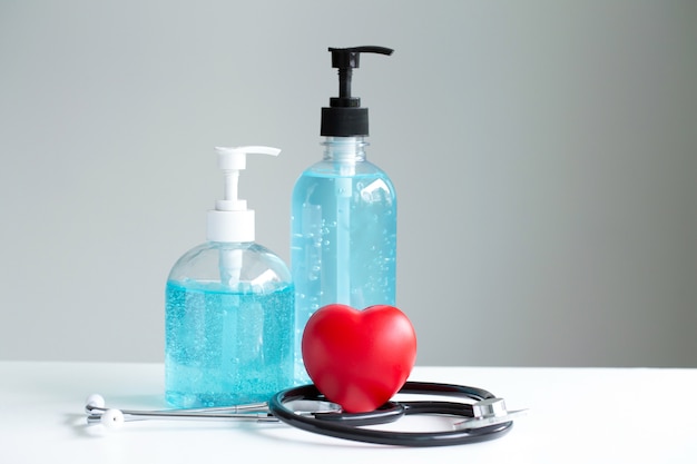 Red heart,hand sanitizer gel,stethoscope on white table. , stop spreading outbreak coronavirus ,health care concept.