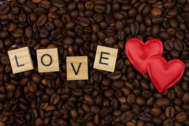 red heart and an inscription of letters on a background of coffee beans Love coffee concept