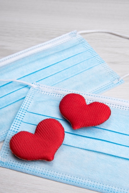 Red heart on medical face masks. Concept support, love, care and a thank you to the frontline essential workers and healthcare .Happy valentines day. Pandemic, quarantine coronavirus.Valentine's Day.