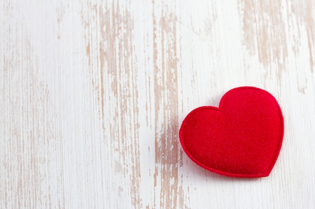 Red heart on old wooden desk