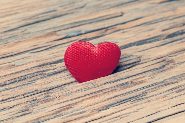 Red heart on old wooden surface