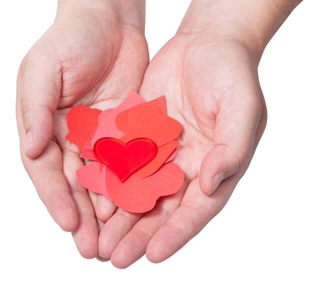 Red heart above pile of paper hearts on male palms