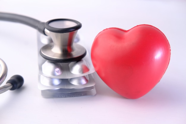 Красное сердце. таблетки и стетоскоп на пустое пространство